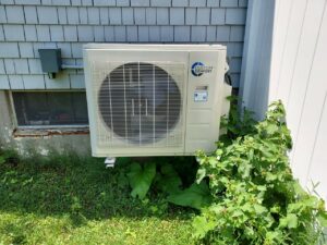 Heat Pump outside of a house with blue siding